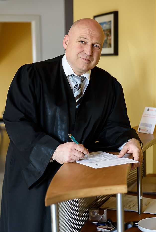 Mann im Anzug unterschreibt Dokument